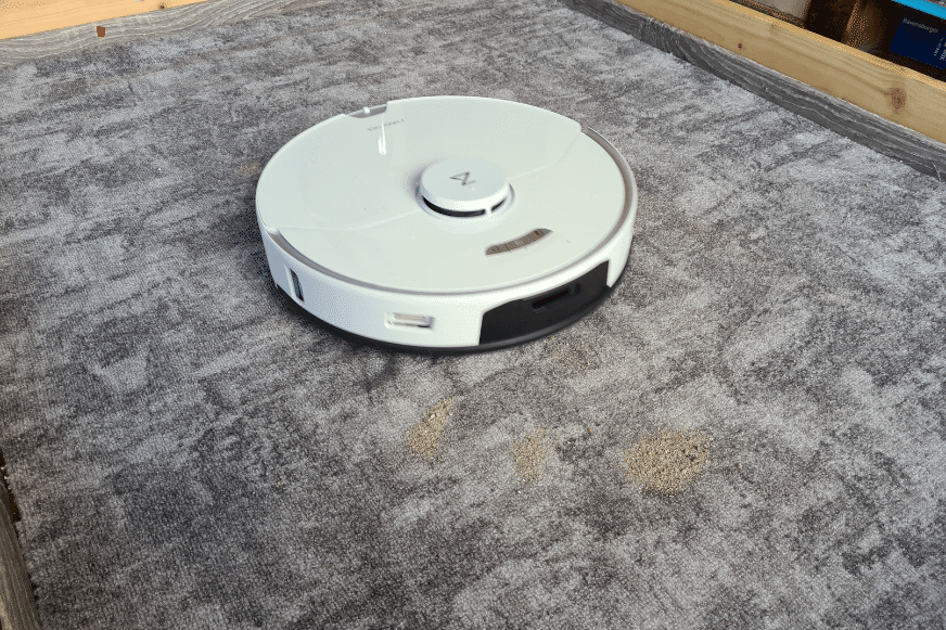 Roborock S7 Pro Ultra beim Sand-Saugtest auf einem niedrigen Teppich 